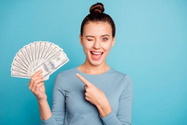 woman holding fanned out cash she received from a personal loan