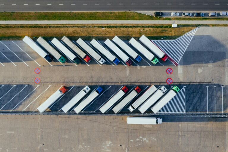 aerial photo of semi trucks lined up in a parking lot
